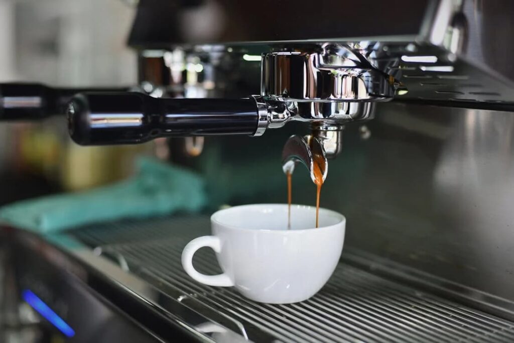 Close-up of espresso pouring into a white cup